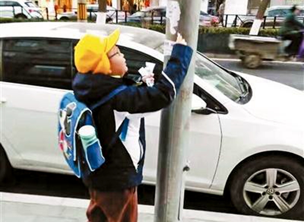 男孩随手撕小广告用行动捍卫自己家园 网友:给