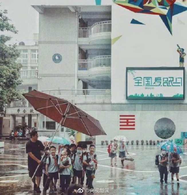 老师用超大雨伞护送学生，家长都在说：太暖了！这是年度感人照片