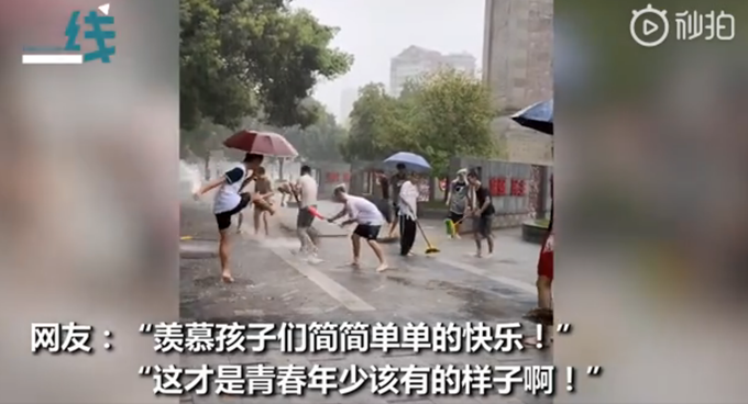 嬉戏学生雨中搞卫生场面逐渐失控，仿佛在过泼水节，网友羡慕