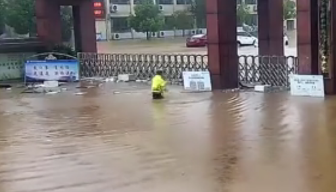 正能量交警小哥游泳到学校门口查看受汛情况，网友：最帅气的泳姿