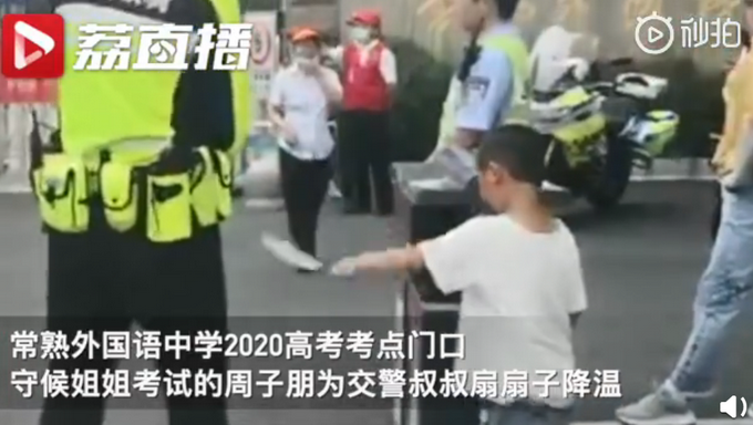 |陪考萌娃为护考交警扇扇子，警察蜀黍怕他累，结果他扇得更起劲了