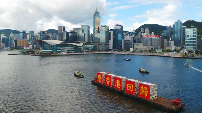 资料图:载着"庆香港回归"标语的船只从香港维多利亚港驶过,庆祝香港