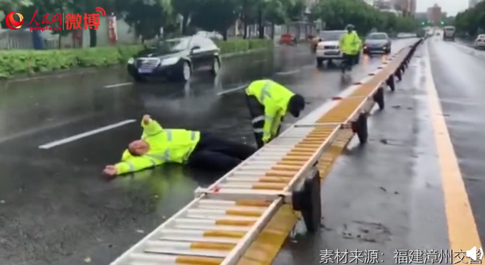 热点|这一幕让人心疼！台风天执勤交警扶护栏被压倒，网友：看着都痛