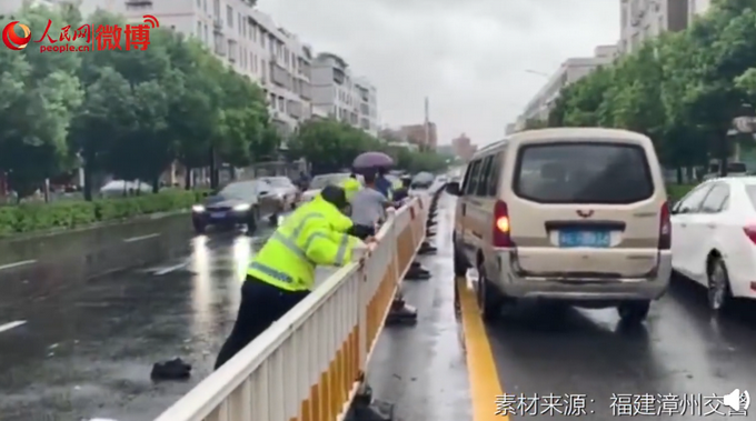 热点|这一幕让人心疼！台风天执勤交警扶护栏被压倒，网友：看着都痛