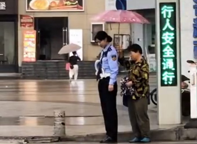 正能量|大妈为雨中默哀的女交警撑伞，网友：你守护国家有人在默默守护你