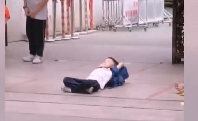 |潮州小学生放学盘腿躺校门口等家长，网友：保证安全就好，多惬意