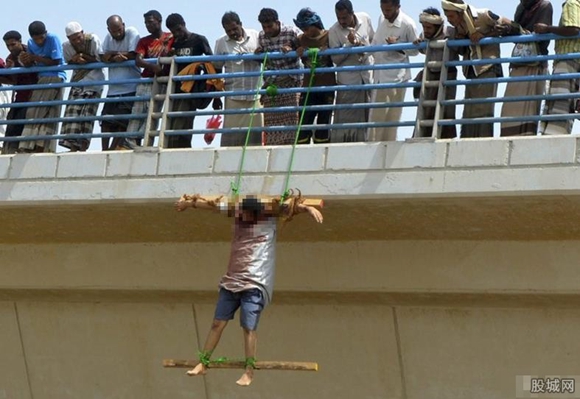当地时间2015年6月17日,也门南部城市mukalla,一名男子的尸体被吊在桥